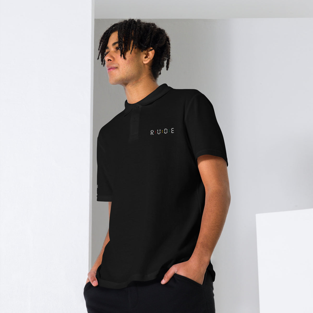 Front view of black unisex pique polo shirt with embroidered Rude logo