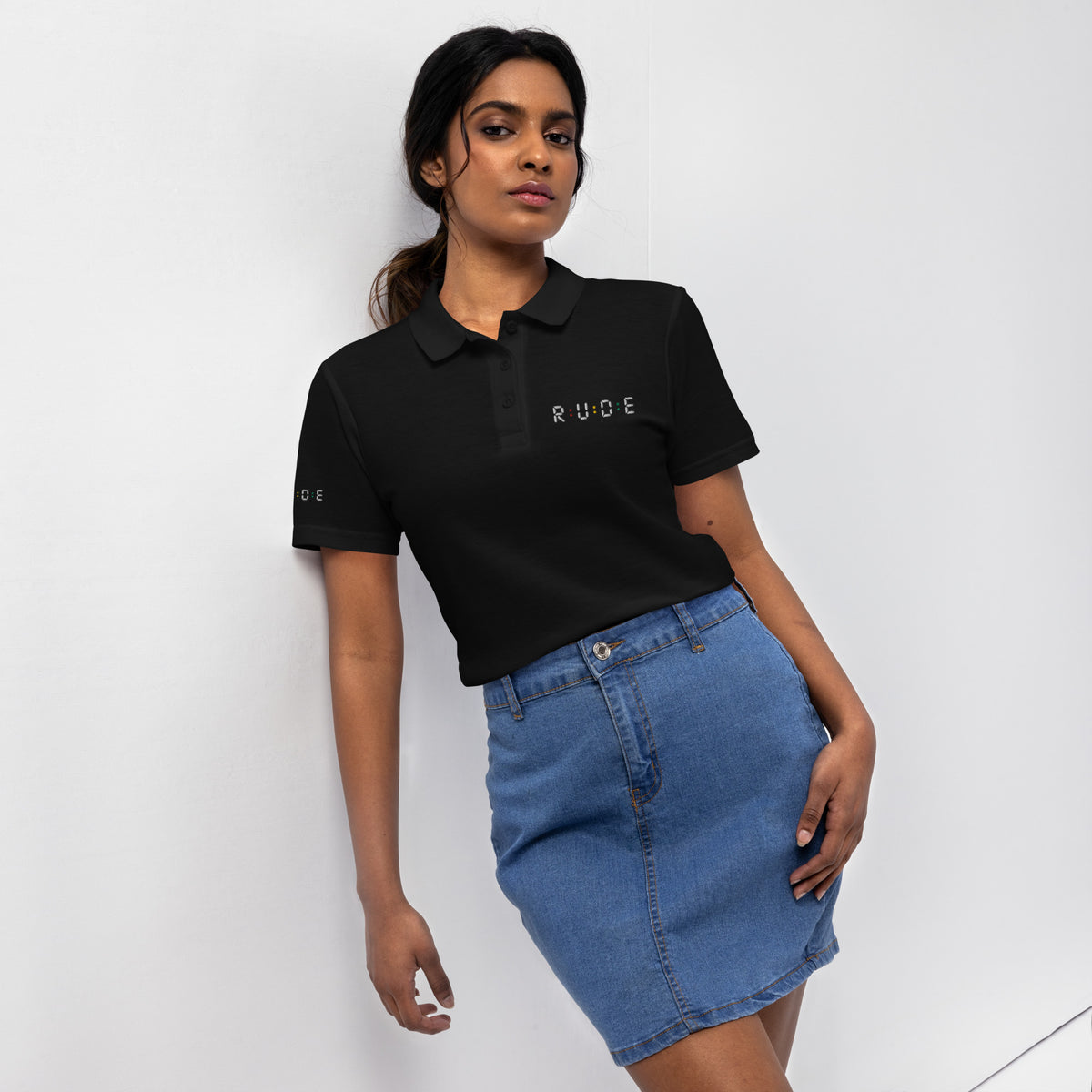 Front view of black women’s pique polo shirt with embroidered Rude logo